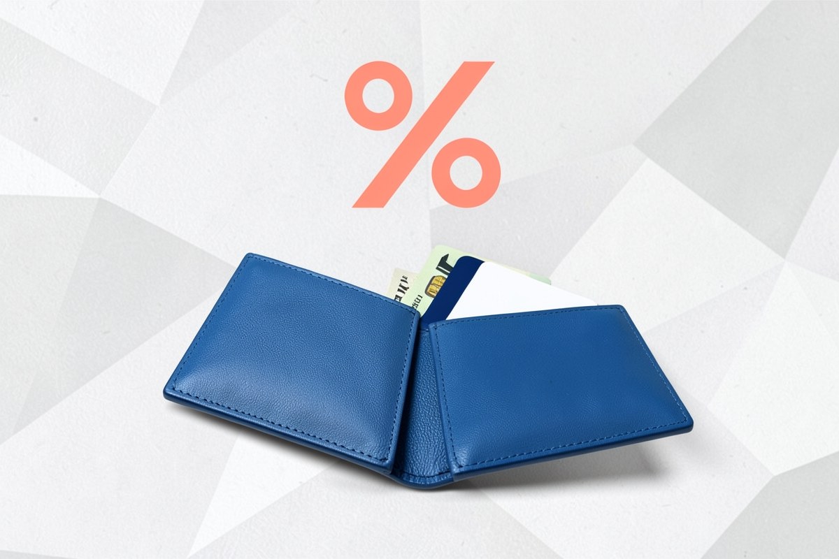 A wallet with several cards and cash, with a stylized percentage symbol hovering above it in a clean graphic style.